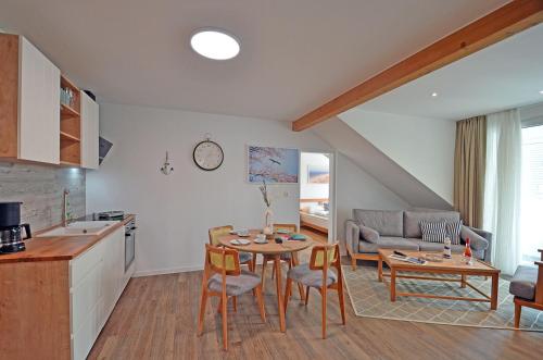 a kitchen and living room with a table and chairs at Am Ufer Top 13 in Dranske