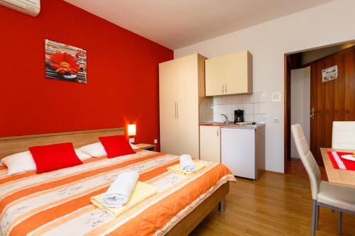 a bedroom with a large bed with red walls at Studio 3 apartmani Braut in Kornić