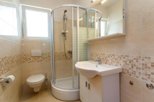 a bathroom with a toilet sink and a shower at Studio 3 apartmani Braut in Kornić