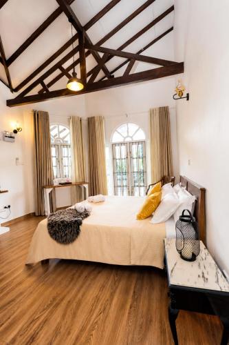 a large bedroom with a large bed and wooden floors at Mino Villa Kandy in Kandy
