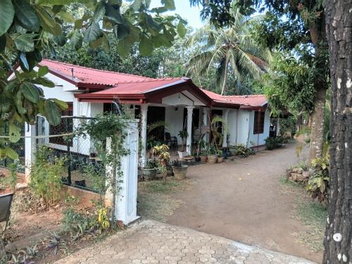 a white house with a red roof at Elephant safari Lodge sigiriya junction in Habarana