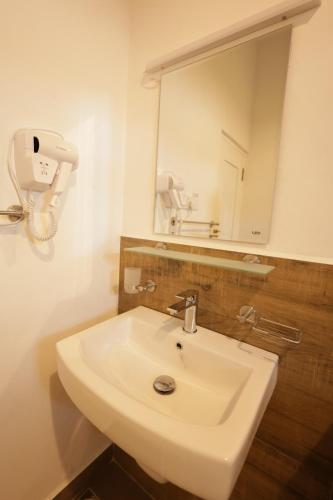 a bathroom with a white sink and a mirror at Mino Villa Kandy in Kandy