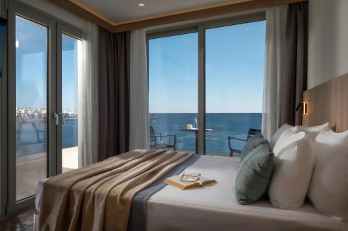 a bedroom with a bed with a view of the ocean at San Marine Beach Hotel, Heart of Chersonissos, Steps from the Sea in Hersonissos