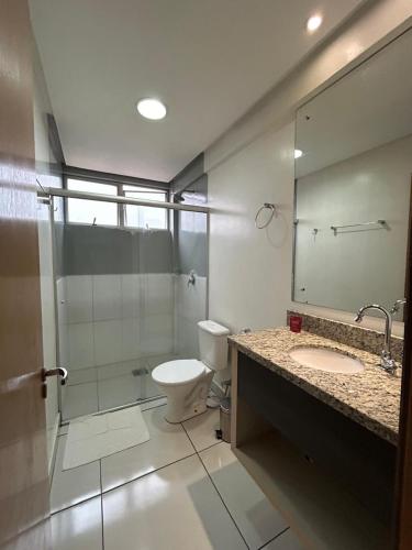 ein Badezimmer mit Toilette und Glasdusche in der Unterkunft Hotel Comoditá Ltda in Sapiranga