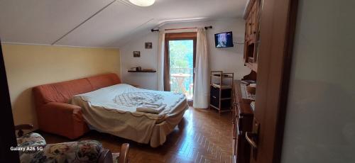 a living room with a couch and a window at La Mansarda di Chiara e Silvio in Trasquera