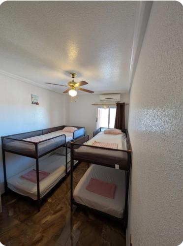 a room with three bunk beds and a ceiling at Casa Lyngra in Orihuela Costa
