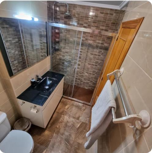 a bathroom with a sink and a shower and a toilet at Casa Lyngra in Orihuela Costa