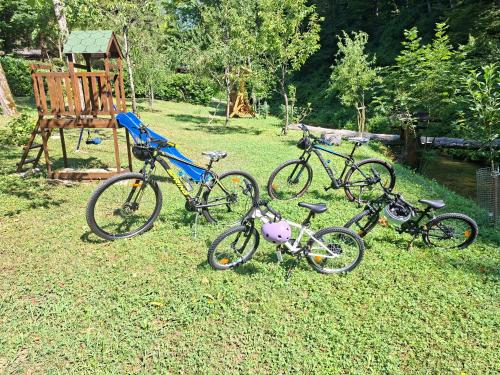 a group of three bikes parked in the grass at Kuća za odmor uz rijeku Slapnica, u Parku prirode Žumberak, finska sauna i jacuzzi in Krašić