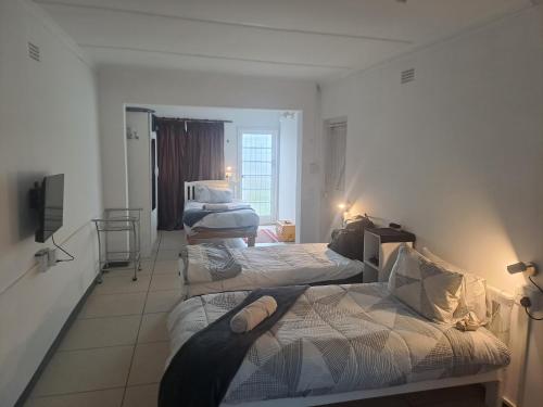 a room with three beds and a tv in it at The haven in George