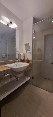 a bathroom with a sink and a shower at Park Hotel in Hévíz