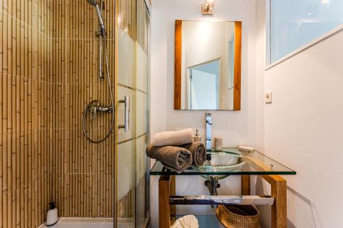 a bathroom with a glass sink and a shower at Villa Saint Barth in Gujan-Mestras