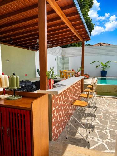 an outdoor kitchen with a counter and chairs at Hebron Gardens House in Kandy