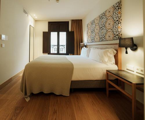 a hotel room with a large bed and a window at Hotel Estepona Plaza in Estepona