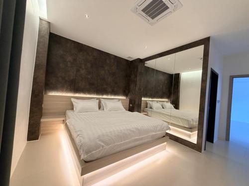 a bedroom with a large bed and a large mirror at LaViena pool villa in Vientiane