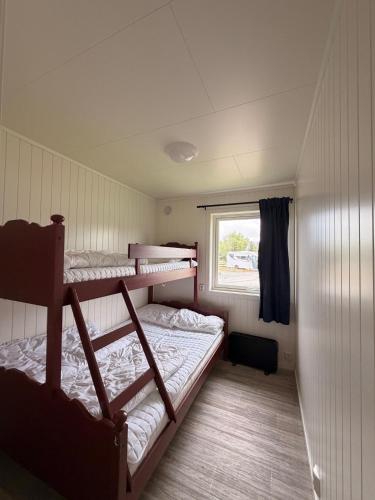 two bunk beds in a room with a window at Saltstraumen camping in Bodø