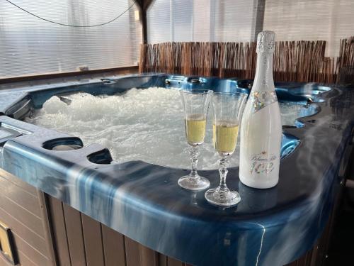 two glasses of champagne in a hot tub with water at Chata Victory in Rajnochovice