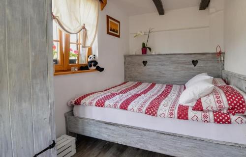 a bedroom with a bed with a red and white comforter at Breg&Spa in Beretinec