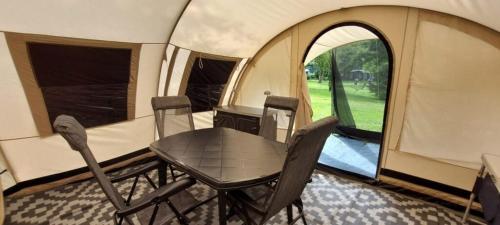 a table and chairs sitting inside of a tent at De Zanglijster in Erica