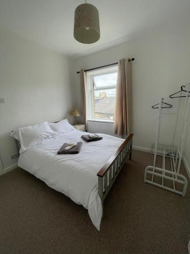 a bedroom with a large white bed with a window at Jagger Green Retreat in Greetland