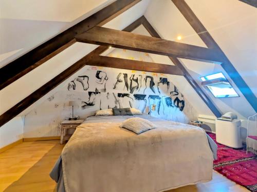 a bedroom with a large bed in a attic at La Passerelle in Loguivy-Plougras