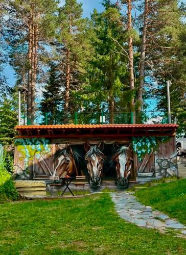 a building with a painting of horses on it at Вила Рози, Семково in Belitsa