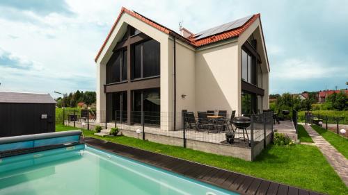 a house with a swimming pool in front of it at Flatbook Stegna Południowa Apartamenty z Basenem in Stegna