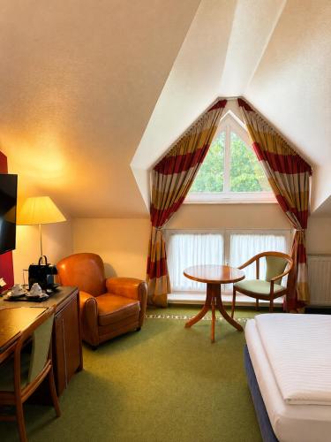 a room with a bed a chair and a table at FlexInn Hotel Gelsenkirchen in Gelsenkirchen