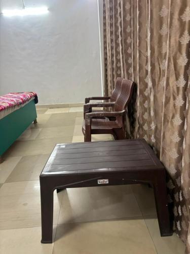 a chair and a table in a room at Hotel RV in Jhānsi
