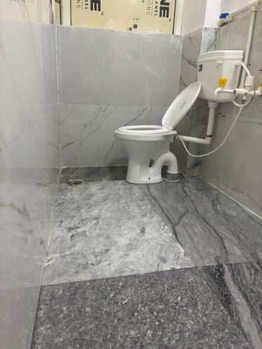 a bathroom with a white toilet in a room at Hotel RV in Jhānsi