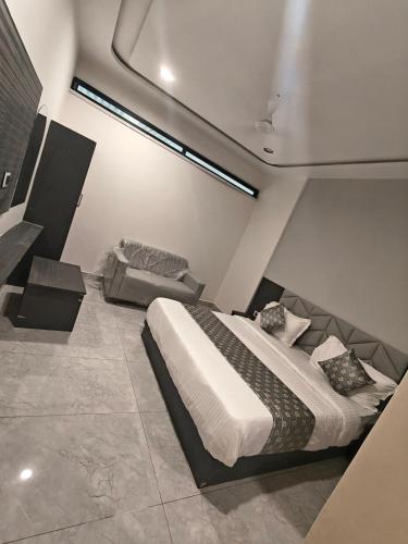 a bedroom with a bed and a couch in it at Hotel Raddizone in Gandhinagar