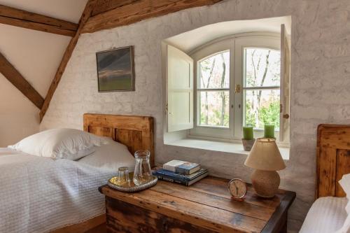 a bedroom with a bed and a window and a wooden table at The Bat Barn in Kelevíz