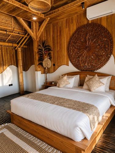 a bedroom with a large bed with wooden walls at JinengBali Eco Lodge in Tegalalang
