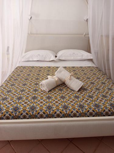a bed with a tie sitting on top of it at Curtigghiu Room in Avola