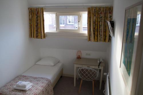 a small room with a bed and a desk and a window at Hotel Verdi in Amsterdam