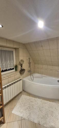 a large bathroom with a tub and a white rug at Leśna Przygoda ,,Balia w cenie" in Harbutowice