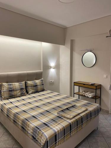 a bedroom with a large bed with a plaid at Folia City Center with Parking in Chalkida