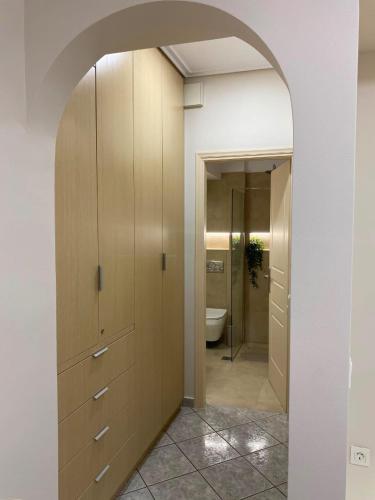 a bathroom with a toilet and a hallway with a mirror at Folia City Center with Parking in Chalkida