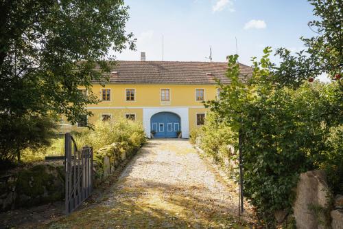 a yellow house with a blue door and a driveway at Statek Zahrádka Český Krumlov in Český Krumlov