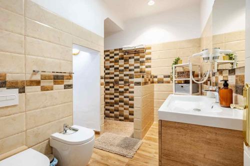 a bathroom with a sink and a toilet and a sink at Casa Teide, disfruta de el atardecer en tu gran terraza privada in Icod de los Vinos