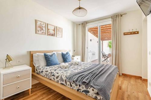 a bedroom with a large bed with blue pillows at Casa Teide, disfruta de el atardecer en tu gran terraza privada in Icod de los Vinos