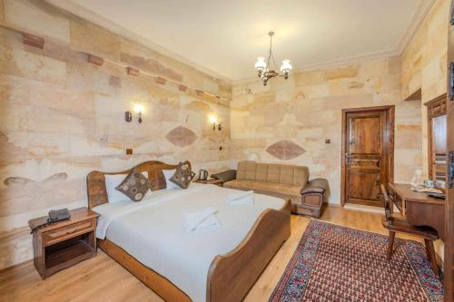 a bedroom with a large bed and a couch at Akuzun Stone Hotel in Ürgüp