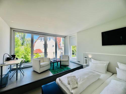 a bedroom with a bed and two chairs and a window at Feldberg4you DesignZimmer in Feldberg