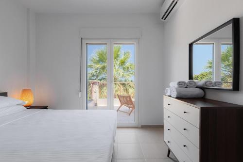 a bedroom with a bed and a dresser and a mirror at Azura Villa #Skgbnb in Mesochórion