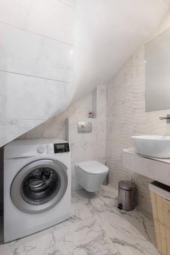 a white bathroom with a washing machine and a sink at Azura Villa #Skgbnb in Mesochórion