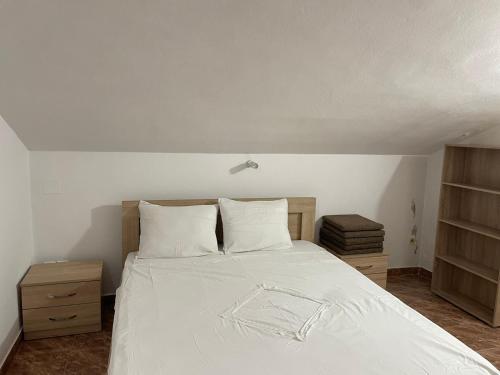a bedroom with a white bed with two pillows at Villa Pistula apartments in Ulcinj