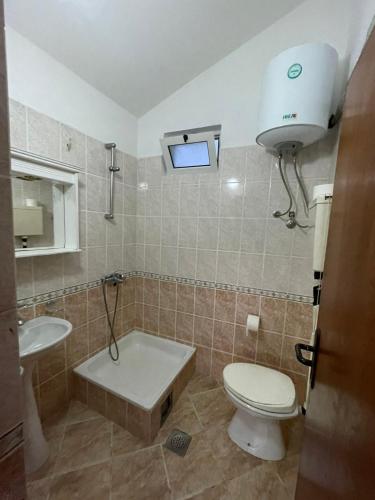 a bathroom with a toilet and a sink and a tub at Villa Pistula apartments in Ulcinj
