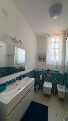 a bathroom with a sink and a toilet and a mirror at Villa Anna in Quartu SantʼElena