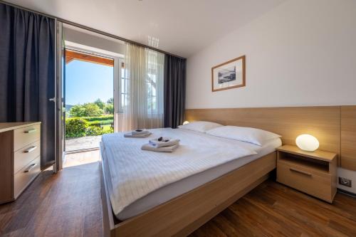 ein Schlafzimmer mit einem großen Bett und einem großen Fenster in der Unterkunft JBX Albatros Lipno in Přední Výtoň