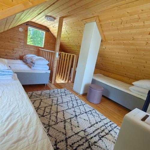 a room with two beds in a wooden cabin at Lomamökki seitsemisen kansallispuiston lähellä in Aurekoski