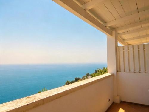 a balcony with a view of the ocean at La Locanda Del Carrubo in Mattinata